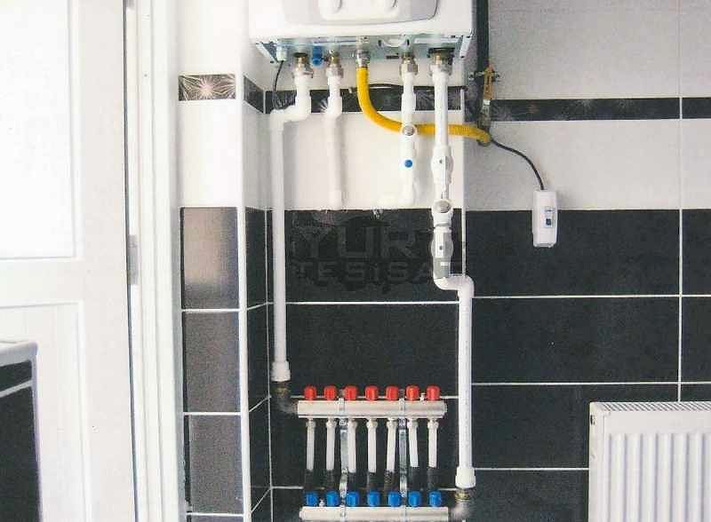 tesisatçının değiştirdiği kombinin doğalgaz ve su tesisatı bağlantıları ile radyatör peteği