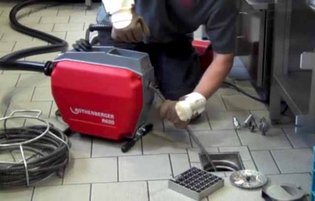 tıkanıklık açma makinesi ile çalışan tesisatçı